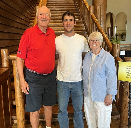 Three people standing in front of stairs 